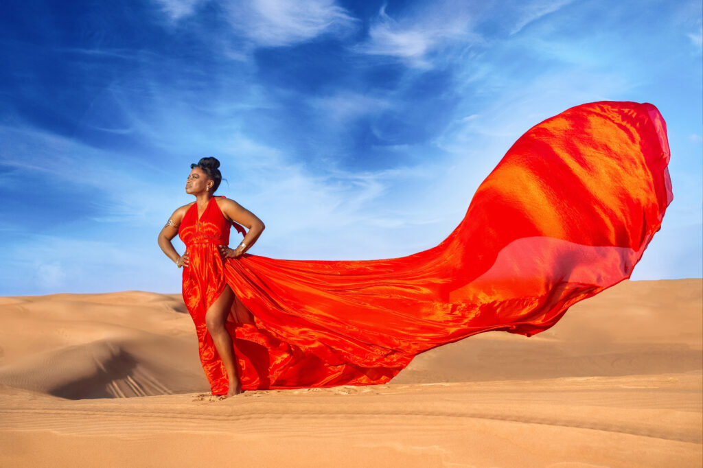 Lady in red flying dress in Dubai Desert