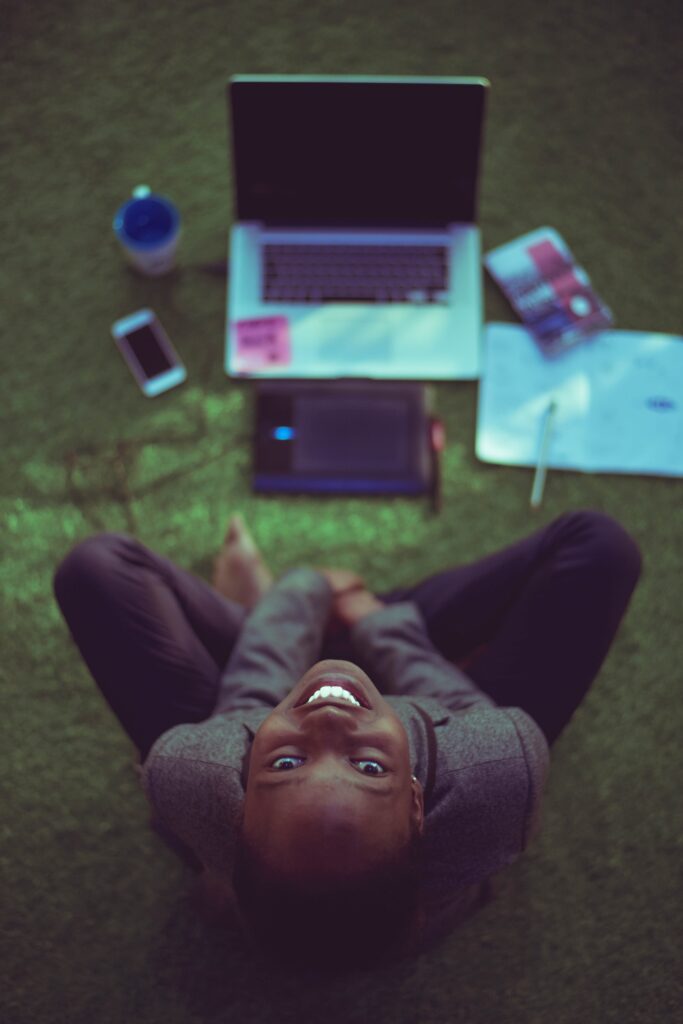 Black woman look up from laptop planning solo trip itinerary