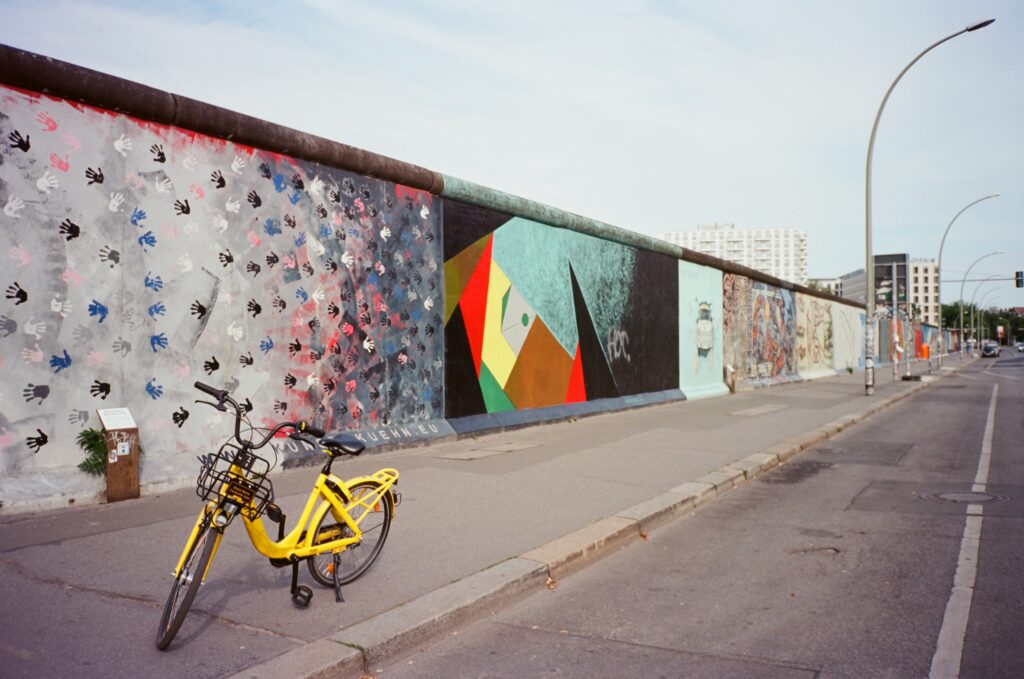 yellow bicycle in front of the Berlin Wall