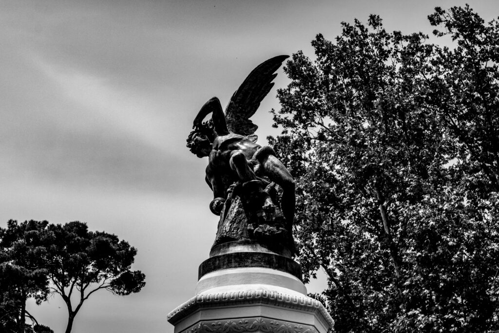 Black and white photo of the statue of fallen Angel in Parque de Retiro