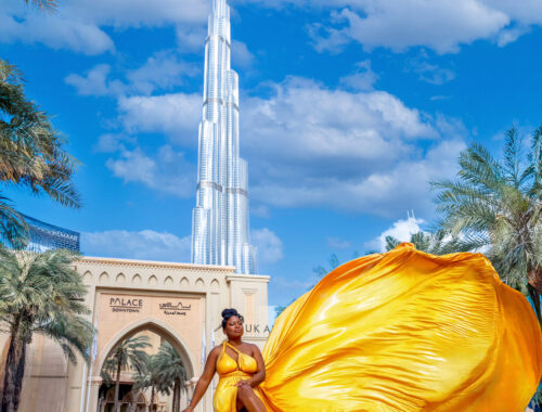 Woman in yellow flying dress in Downtown Palace Dubai with Burj Khalifa in background